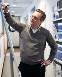 Unternehmensberater Matthias Dehn schreibt auf einem Whiteboard