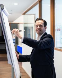 Unternehmensberater Maximilian Meier schreibt auf Flipchart