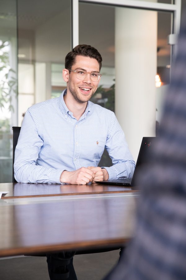 Unternehmensberater Lennart Rittmeyer sitzt mit Laptop am Tisch