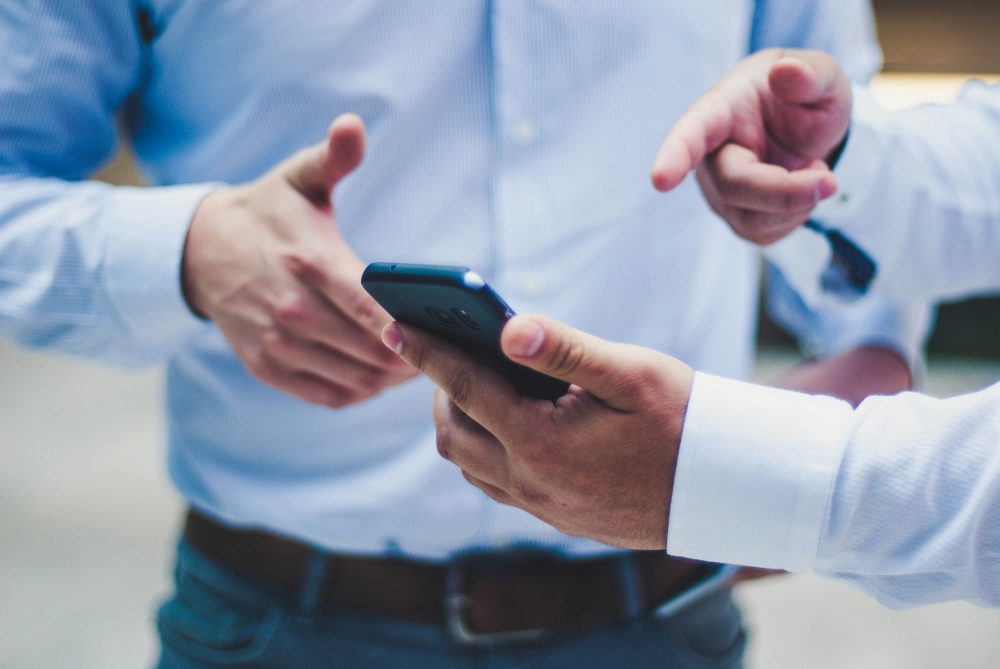 Hand zeigt auf Smartphone