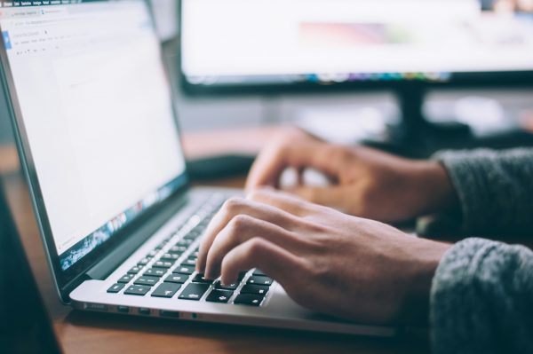 Hände schreiben auf dem Laptop